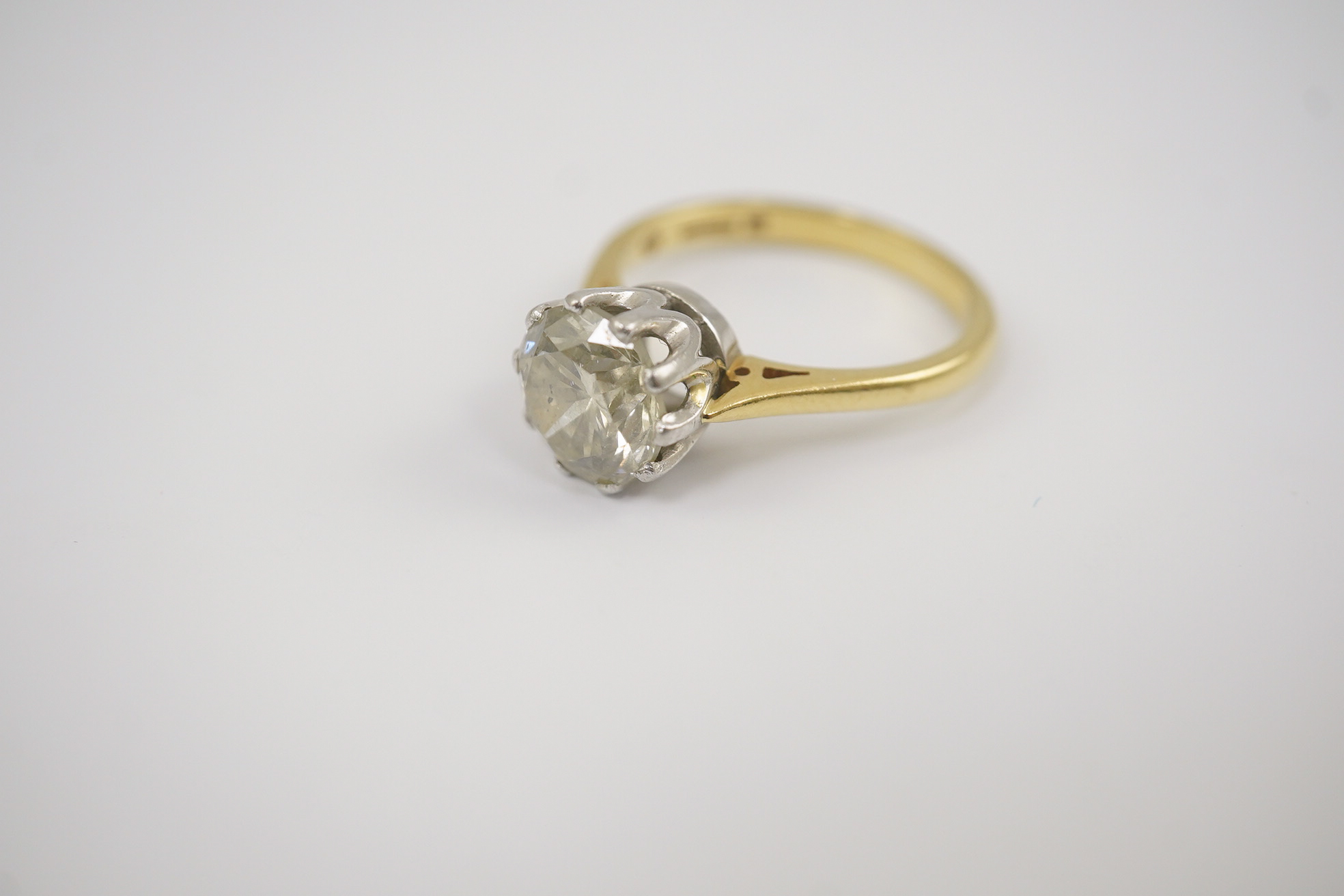 A modern 18ct gold and solitaire round cut diamond set ring